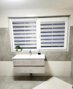 A&G SoDYBA LIUXAPARTAMENT في بلونج: حمام مع حوض ونافذة