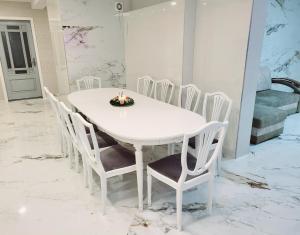 a white dining room table and chairs with candles on it at A&G SoDYBA LIUXAPARTAMENT in Plungė