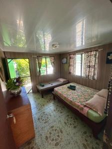 a bedroom with a bed in a room with windows at Motu Tahuhu Lodge in Rangiroa