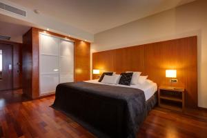 - une chambre avec un grand lit et un mur en bois dans l'établissement La Posada Huamanguina, à San Antonio