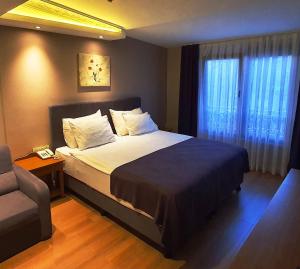 une chambre avec un lit, une chaise et une fenêtre dans l'établissement La Posada Huamanguina, à San Antonio