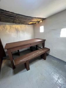 um banco de madeira sentado dentro de uma sala em Casa AB em Zipaquirá