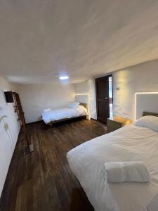 um quarto de hotel com duas camas e piso de madeira em Casa AB em Zipaquirá