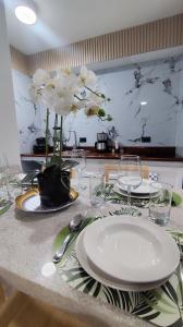 una mesa con platos, vasos y flores. en Hospedaje en Valencia Tipo Estudio, en Valencia 8 fotos más