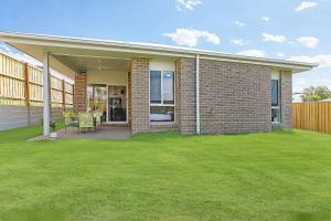a brick house with a lawn in front of it at Comfy Home in Deebing Heights in Loamside