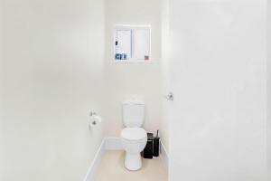 a white bathroom with a toilet and a window at Comfy Home in Deebing Heights in Loamside +23 photos