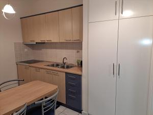 约阿尼纳Cozy Corner Melandra的厨房配有桌子、水槽和橱柜。