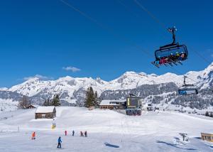 a group of people riding a ski lift in the snow at Louisa's Loft - Auszeit in den Bergen & der Natur für Familien, Freunde und Paare - Wandern & Seen - 1h ab Zürich in Alt Sankt Johann