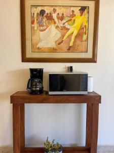 a microwave on a wooden table with a painting at Garden and Pool Casita in La Paz