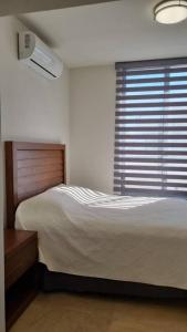 Los BledalesCasa Del Sol的一间卧室配有一张床和一个带风扇的窗户。