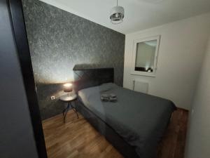 a bedroom with a bed and a table with a lamp at Eleon in Novi Sad
