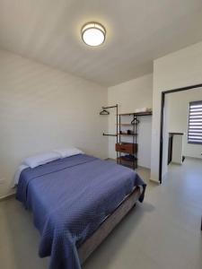 Los BledalesCasa Cielo的一间卧室，里面有一张床，铺着蓝色被子。