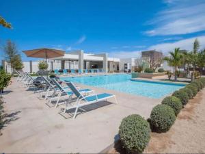 Los BledalesCasa Nopal的带躺椅和遮阳伞的游泳池