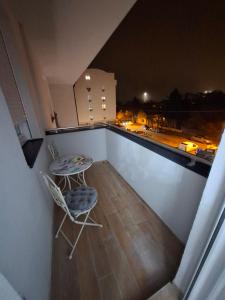 a table and chairs on a balcony at night at Eleon in Novi Sad