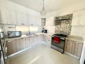 Los BledalesWater House的配有木制橱柜和炉灶烤箱的厨房