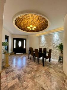 una sala da pranzo con tavolo, sedie e lampadario di Casa Flor y Agua a La Ardilla