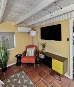 a living room with a tv and a red chair at Mid-century marvelous 1 bed, pets welcome in Las Cruces