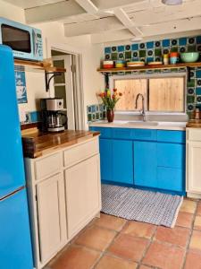 a kitchen with blue cabinets and a sink at Mid-century marvelous 1 bed, pets welcome in Las Cruces