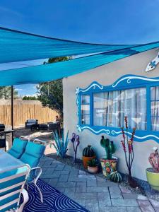 a patio with a blue canopy and some plants at Mid-century marvelous 1 bed, pets welcome in Las Cruces +7 photos