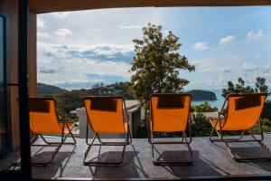 three chairs sitting on a porch looking out a window at Barad Lux Villa in Mae Haad