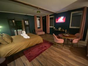 a bedroom with a bed and a table and chairs at Le Nid des Cardamines in Sainte-Eusoye