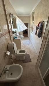 Un baño con lavabo, inodoro y espejo. en Maison portugal, en Caria