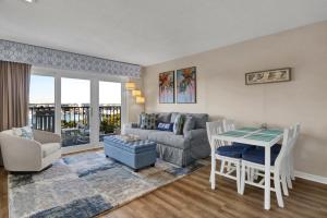 a living room with a couch and a table at Summer Sands - 401 by Sea Scape Properties in Wrightsville Beach