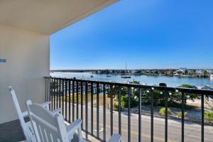 a balcony with two chairs and a view of the water at Summer Sands - 401 by Sea Scape Properties in Wrightsville Beach