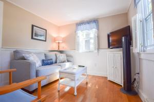 een woonkamer met een bank en een tv bij Private Association Pool Great Location in Wellfleet