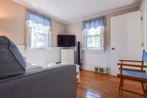 een woonkamer met een bank en twee ramen bij Private Association Pool Great Location in Wellfleet