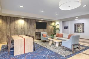 a lobby with a couch and chairs and a tv at Candlewood Suites Midland by IHG in Midland