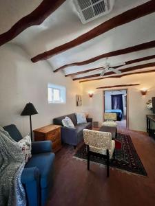 ein Wohnzimmer mit einem blauen Sofa und Stühlen in der Unterkunft 2 bed, yard, pet friendly in Historic Mesilla. in Mesilla