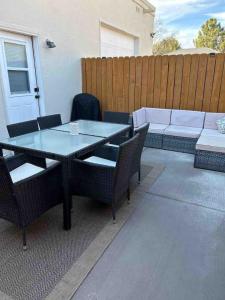 een terras met een tafel, stoelen en een bank bij Spacious studio near Mesilla in Mesilla
