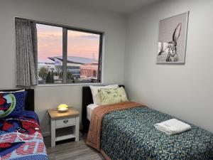 a small bedroom with a bed and a window at Charming & Cozy Apartment in the Heart of Auckland - 2 bd-2 bth-free carpark in Auckland