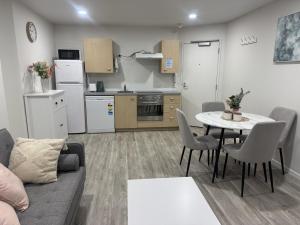 a living room with a couch and a table and a kitchen at Charming & Cozy Apartment in the Heart of Auckland - 2 bd-2 bth-free carpark in Auckland