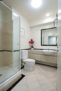 a bathroom with a toilet and a sink and a mirror at Chic Hotel Room at City Life Auckland in Auckland