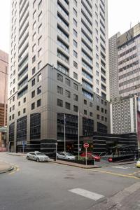 a large building with cars parked in front of it at Chic Hotel Room at City Life Auckland in Auckland
