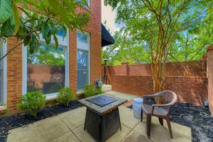 a patio with a table and a chair and a brick wall at The Landing at Wheat St. 2Br in Columbia