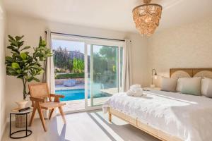 Un dormitorio con una cama y una ventana grande. en Marbella Lane - Vibrant & Chic Designer Home, en Buena Park