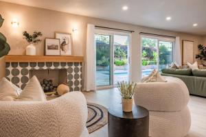 Una sala de estar con dos sillas y una chimenea. en Marbella Lane - Vibrant & Chic Designer Home, en Buena Park