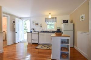 a kitchen with white cabinets and a white refrigerator at Private Association Pool Great Location in Wellfleet