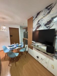 Un comedor con una mesa con sillas y un televisor grande. en Apt Vista Mar Completo próx Praias da litoranea, en São Luís 11 fotos más