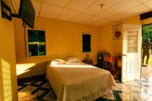 a bedroom with a bed and a tv in it at Hotel Castillo Blanco in El Zonte