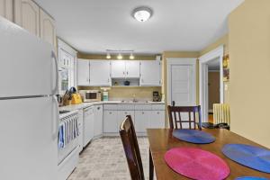 een keuken met een tafel, stoelen en een koelkast bij Midstream Modern 2BR Wi-Fi Parking in St. John's