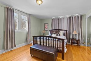 een slaapkamer met een bed, een stoel en ramen bij Midstream Modern 2BR Wi-Fi Parking in St. John's