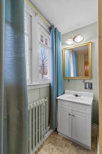 een badkamer met een wastafel, een spiegel en een radiator bij Midstream Modern 2BR Wi-Fi Parking in St. John's +7 foto's