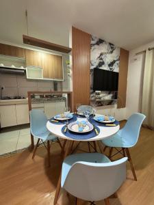 una mesa y sillas con platos y copas de vino. en Apt Vista Mar Completo próx Praias da litoranea, en São Luís