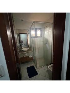 um banheiro com chuveiro, pia e vaso sanitário em Suíte Beleza do amor V11 A em Pipa