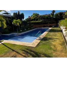 uma piscina em um quintal com palmeiras em Suíte Beleza do amor V11 A em Pipa