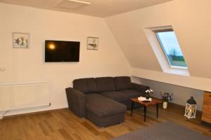 a living room with a couch and a tv at Ferienwohnung Am Sieler in Südbrookmerland